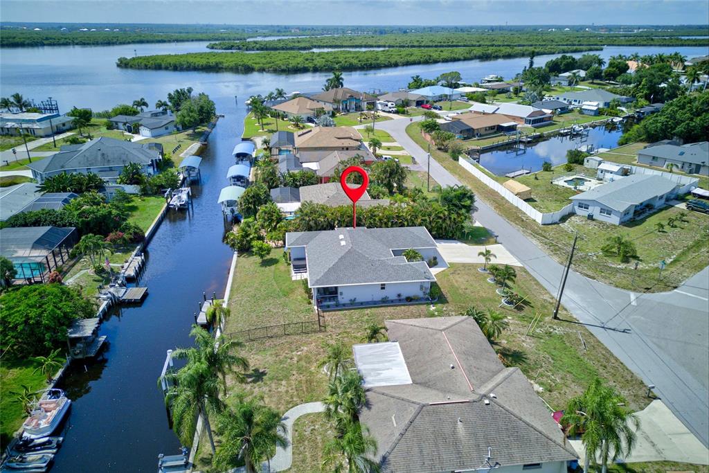 An aerial view shows a single-story house with a backyard, dock, and canal access — 3104 SEAFARER DRIVE, PUNTA GORDA, FL