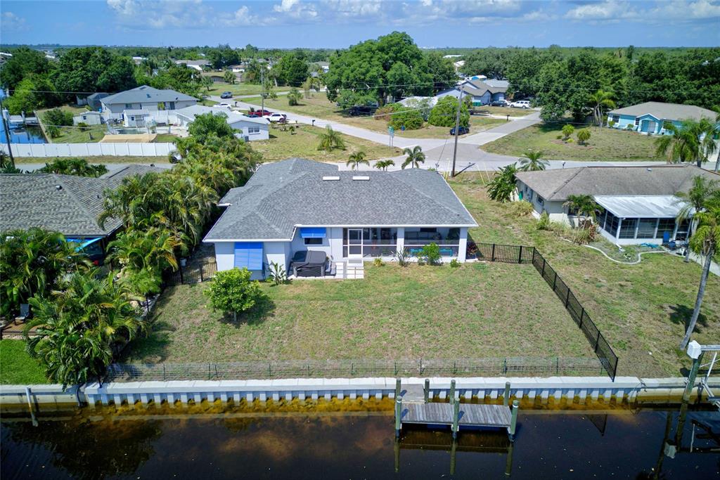 The exterior of a house features a yellow front door and a landscaped garden bed — 3104 SEAFARER DRIVE, PUNTA GORDA, FL