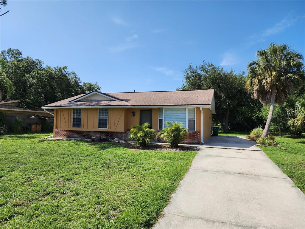 A single-story house with a tan exterior, brick base, and a concrete driveway — 1225 ARMSDALE AVENUE, PORT CHARLOTTE, FL