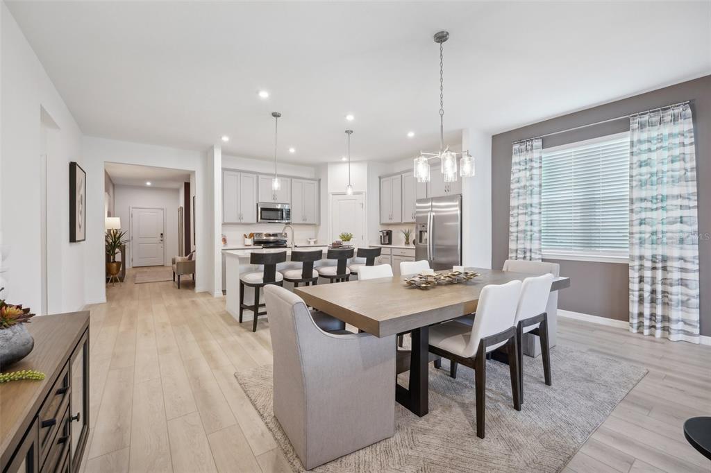 A dining area with a wooden table and chairs sits adjacent to an open kitchen — 1709 FLAG STREET, HAINES CITY, FL