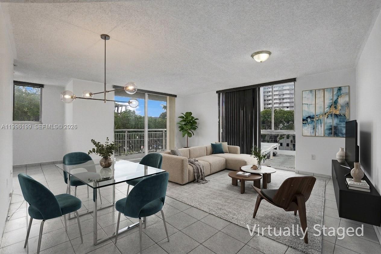 This virtually staged living and dining area features tile flooring, large windows, and a balcony — 1688 West Ave # 408, Miami Beach FL 33139, MIAMI BEACH, FL