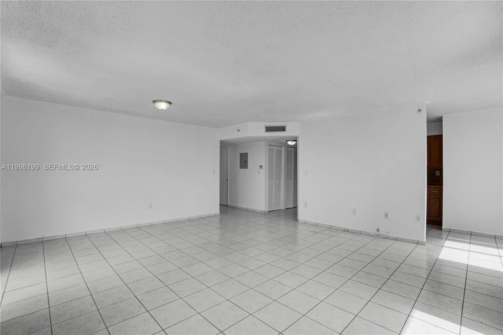 A spacious, empty room features white walls, white tile flooring, and recessed lighting — 1688 West Ave # 408, Miami Beach FL 33139, MIAMI BEACH, FL