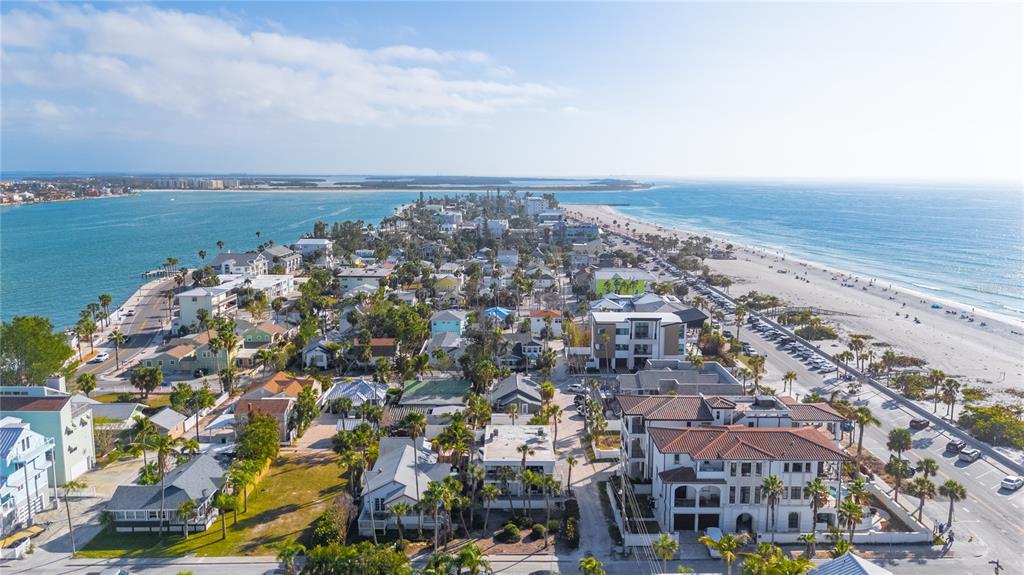 An aerial view of a coastal neighborhood featuring houses, palm trees, and a sandy beach — 108 14TH AVENUE UNIT 2, ST PETE BEACH, FL