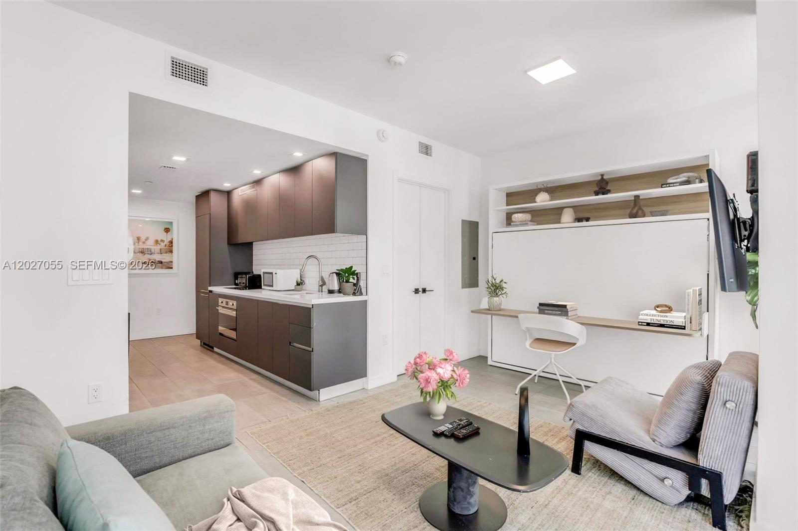A studio apartment features a kitchenette, a wall bed with a desk, and a living area — 227 NE 2nd St # 2611, Miami FL 33132, MIAMI, FL