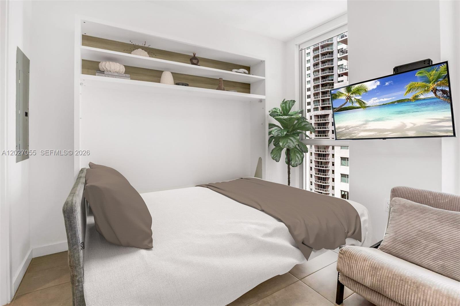 A bedroom features a wall bed, built-in shelving, a television, and a view of high-rise buildings — 227 NE 2nd St # 2611, Miami FL 33132, MIAMI, FL