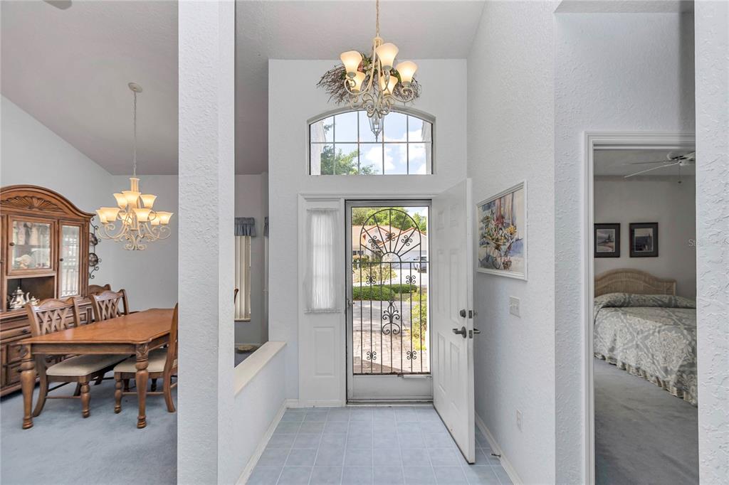 An entryway with tile flooring, a chandelier, and a view into a dining room — 11496 SW 82ND COURT ROAD, OCALA, FL