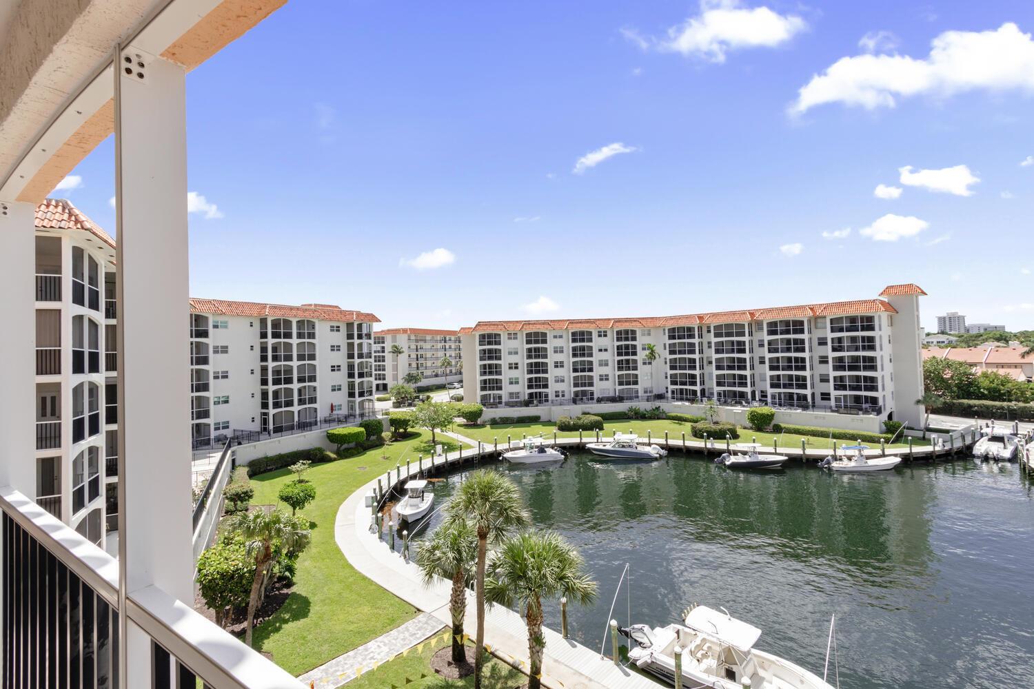 A high-angle view of a residential complex with a central canal, boat slips, and landscaping — 2871 N Ocean Boulevard # V443, Boca Raton FL 33431, BOCA RATON, FL