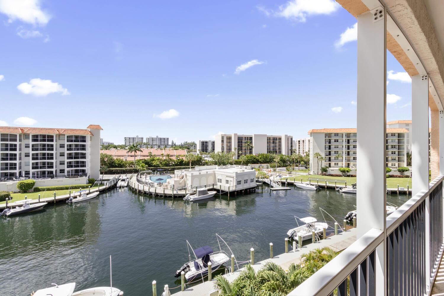 A view from a balcony overlooking a canal with boats and surrounding apartment buildings — 2871 N Ocean Boulevard # V443, Boca Raton FL 33431, BOCA RATON, FL