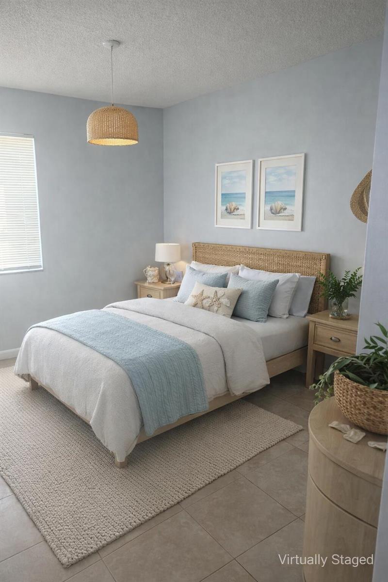 This bedroom features a rattan headboard, light blue walls, and a woven pendant light — FORT LAUDERDALE, FL