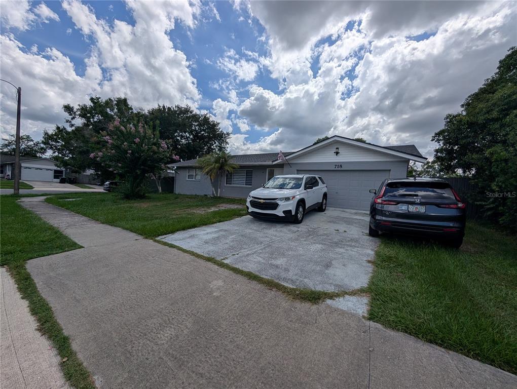 A single-story house with a gray exterior, a two-car garage, and two parked vehicles — 718 PARK MANOR DRIVE, ORLANDO, FL