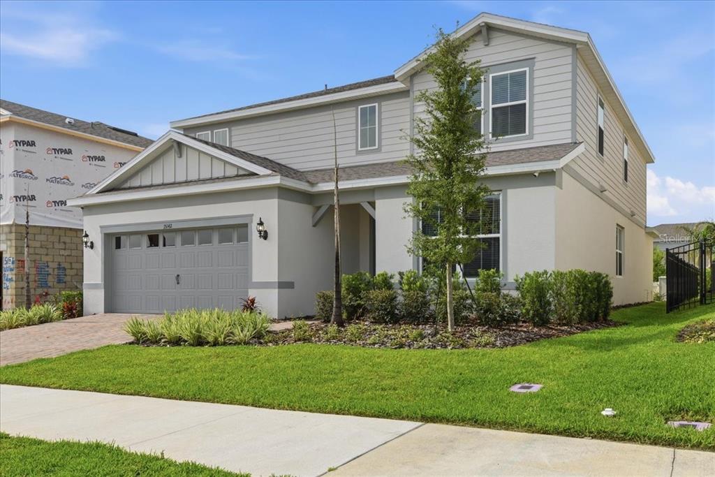 A two-story suburban house with gray siding, a two-car garage, and a manicured front lawn — 15142 WILLOW RIDGE DRIVE, MONTVERDE, FL