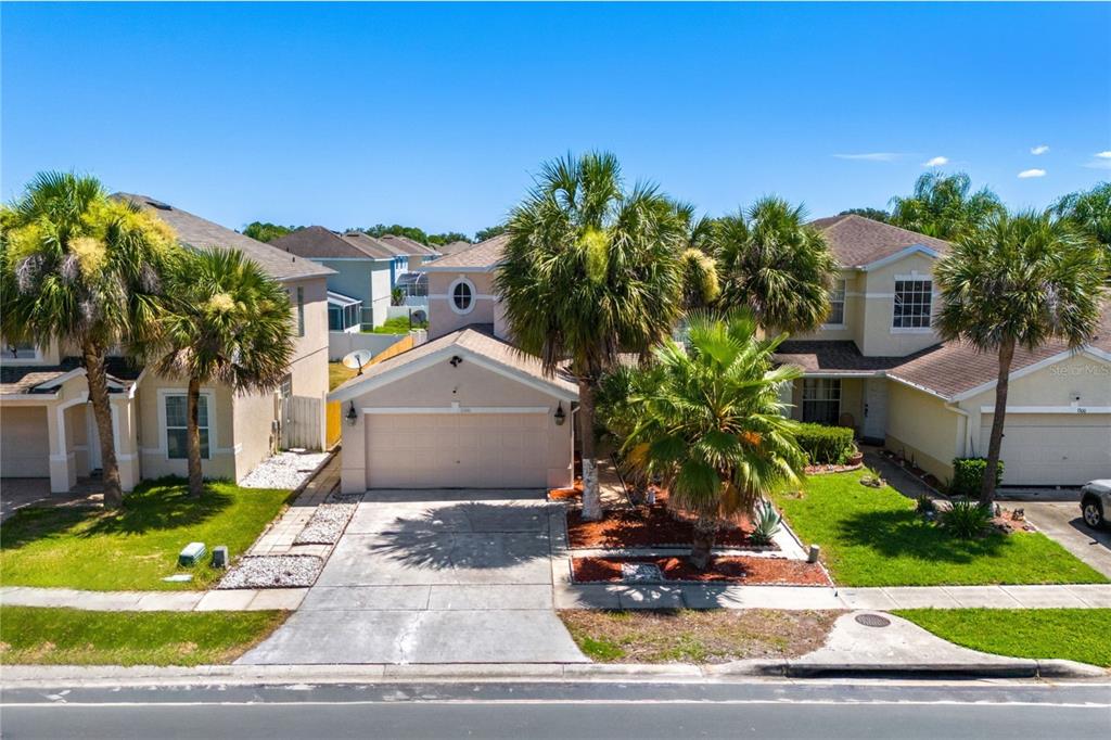 A two-story suburban house with a two-car garage and several palm trees in front — 1304 TIMBERBEND CIRCLE, ORLANDO, FL