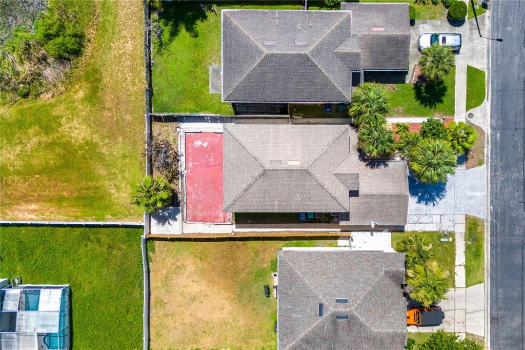 An aerial view shows three suburban houses with yards, a red patio, and a driveway — 1304 TIMBERBEND CIRCLE, ORLANDO, FL