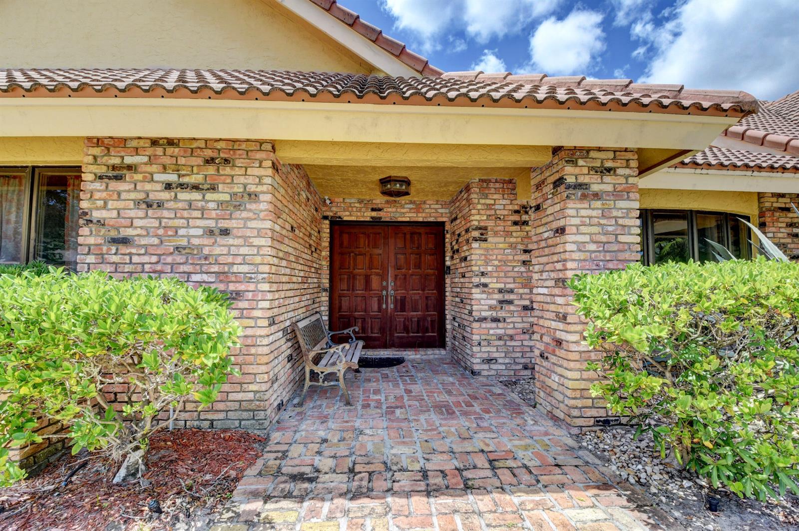 A brick-paved walkway leads to the double wooden front doors of a brick house — 3110 Equestrian Drive, Boca Raton FL 33434, BOCA RATON, FL