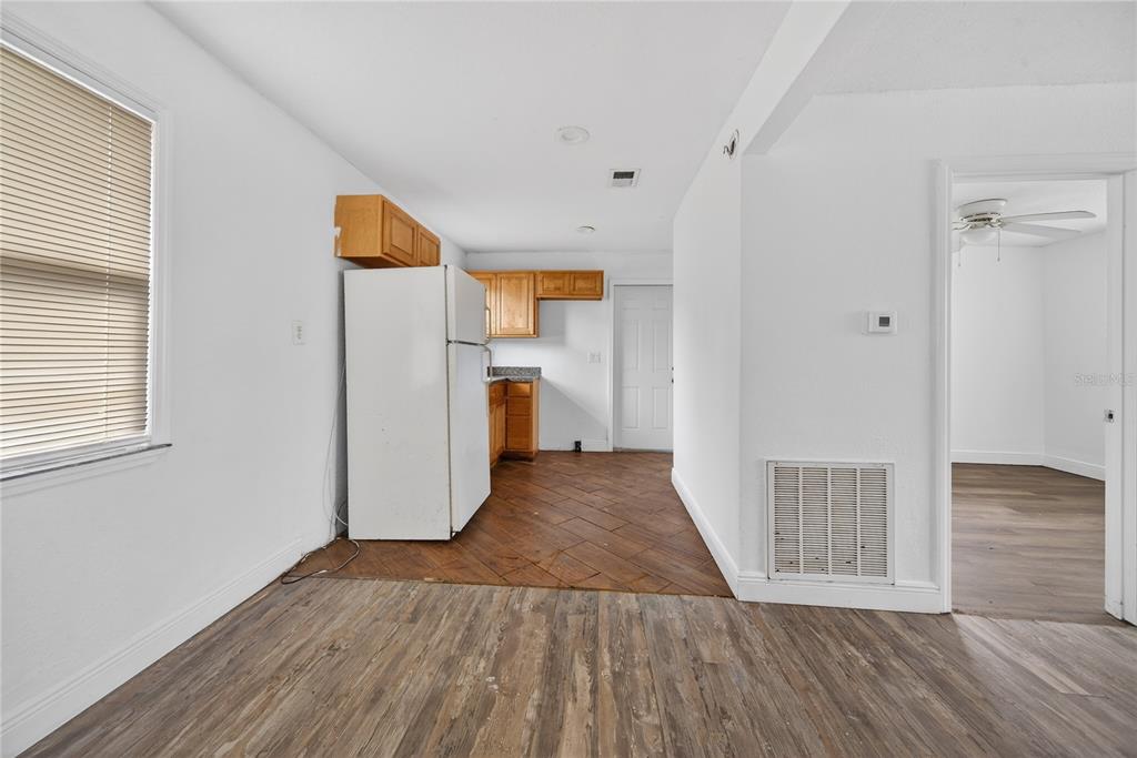 A kitchen with wood-look flooring, white walls, a white refrigerator, and light wood cabinets — 514 S GRANNIS AVENUE, TITUSVILLE, FL