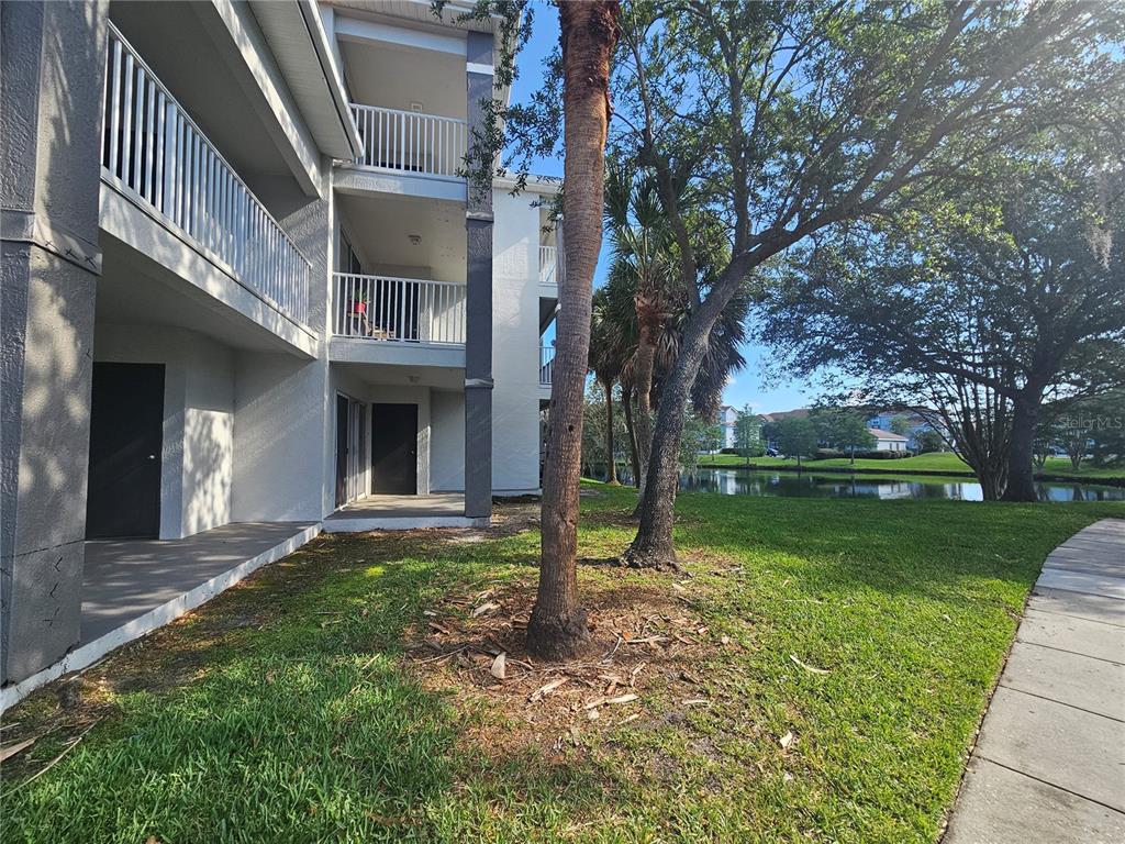 The exterior of a multi-story apartment building features balconies, a patio, and a grassy lawn — 13838 FAIRWAY ISLAND DRIVE UNIT 1418, ORLANDO, FL