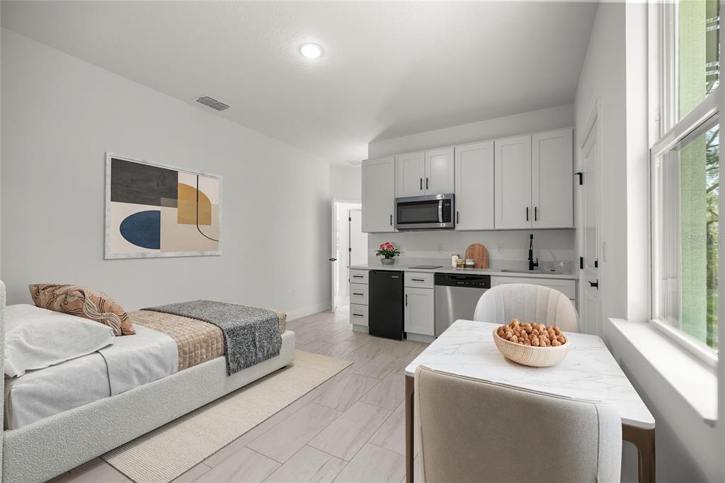 A studio apartment features a bed, a small kitchenette with white cabinets, and a dining table — 10735 N MALVA WAY DRIVE, CITRUS SPRINGS, FL