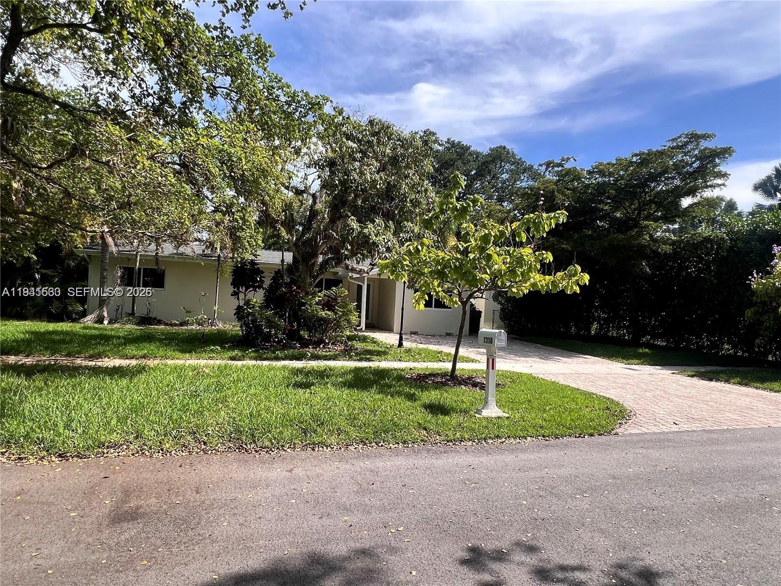 A single-story house with a paved driveway and a large tree in the front yard — 7350 SW 96th St # 7350, Pinecrest FL 33156, PINECREST, FL