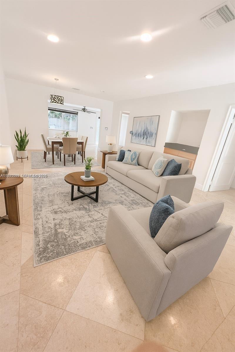 A bright living room features light-colored tile floors, a neutral sofa, and a dining area — 7350 SW 96th St # 7350, Pinecrest FL 33156, PINECREST, FL