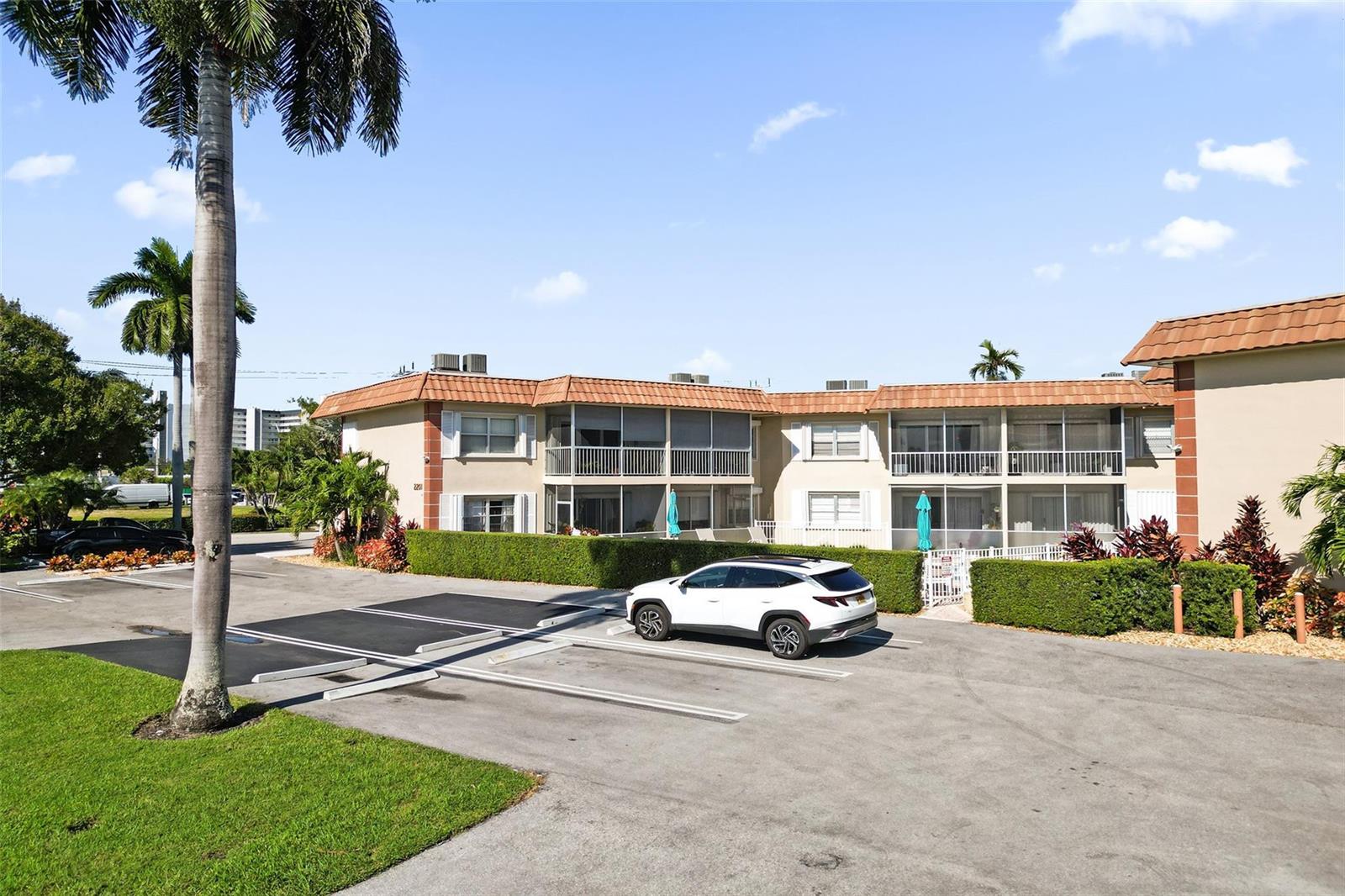 A white SUV is parked in front of a two-story apartment building with balconies — 2201 SE 9th Street # 106, Pompano Beach FL 33062, POMPANO BEACH, FL