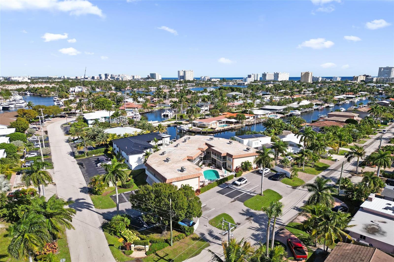 An aerial view shows a multi-unit residential building with a pool surrounded by palm trees — 2201 SE 9th Street # 106, Pompano Beach FL 33062, POMPANO BEACH, FL