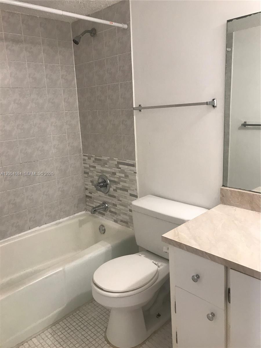 A bathroom features a tiled shower-tub combo, a white toilet, and a vanity with a mirror — 5112 NW 79 AV # 201, Doral FL 33166, DORAL, FL