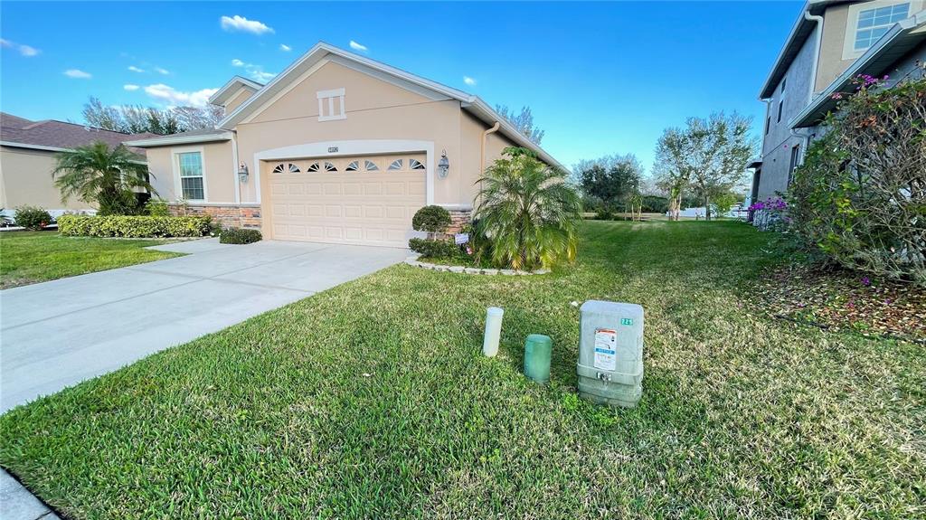 A tan single-story house with a two-car garage and a green lawn — 14112 QUEENSIDE ST, ORLANDO, FL