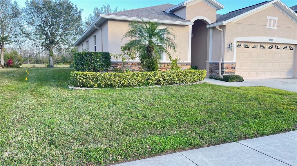 A single-story house with a beige stucco exterior, stone accents, and a two-car garage — 14112 QUEENSIDE ST, ORLANDO, FL