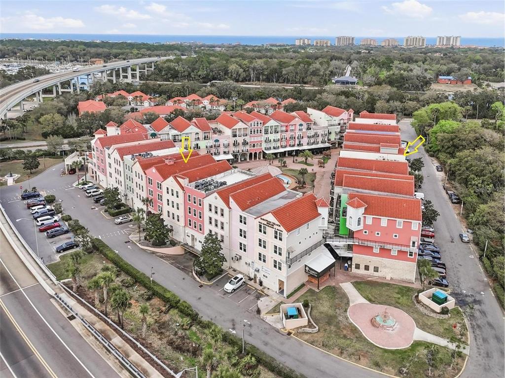 An aerial view shows a multi-story residential complex with red tile roofs and parking lots — 101 PALM HARBOR PARKWAY, PALM COAST, FL
