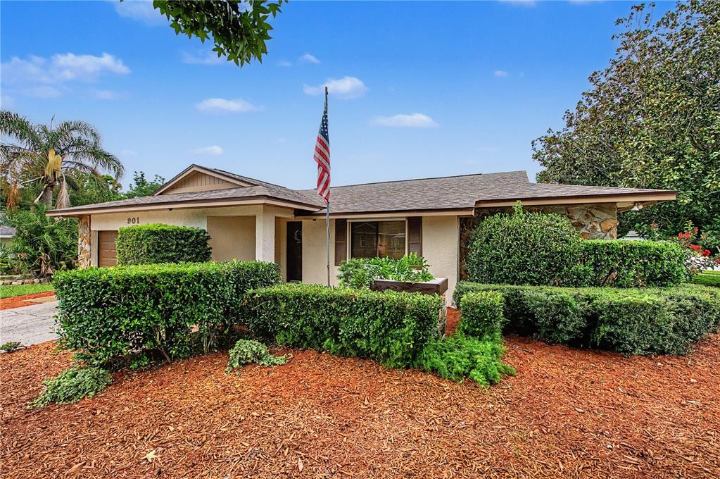 A single-story house with a stone facade, a flag pole, and manicured hedges in front — 901 TARAWOOD LANE, VALRICO, FL