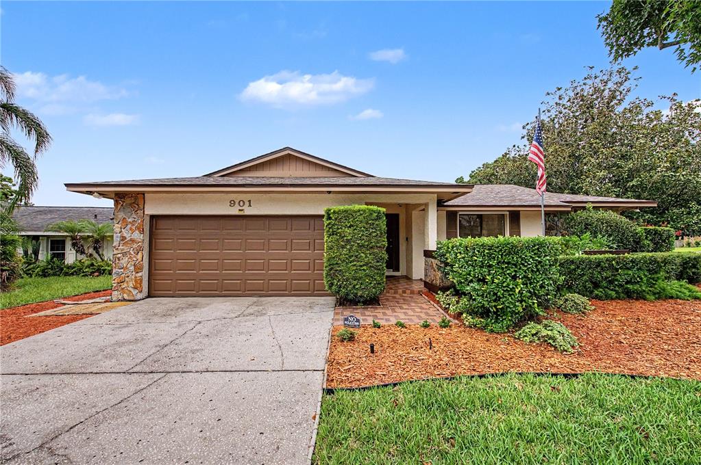 A single-story house with a brown garage door, stone accents, and a landscaped front yard — 901 TARAWOOD LANE, VALRICO, FL