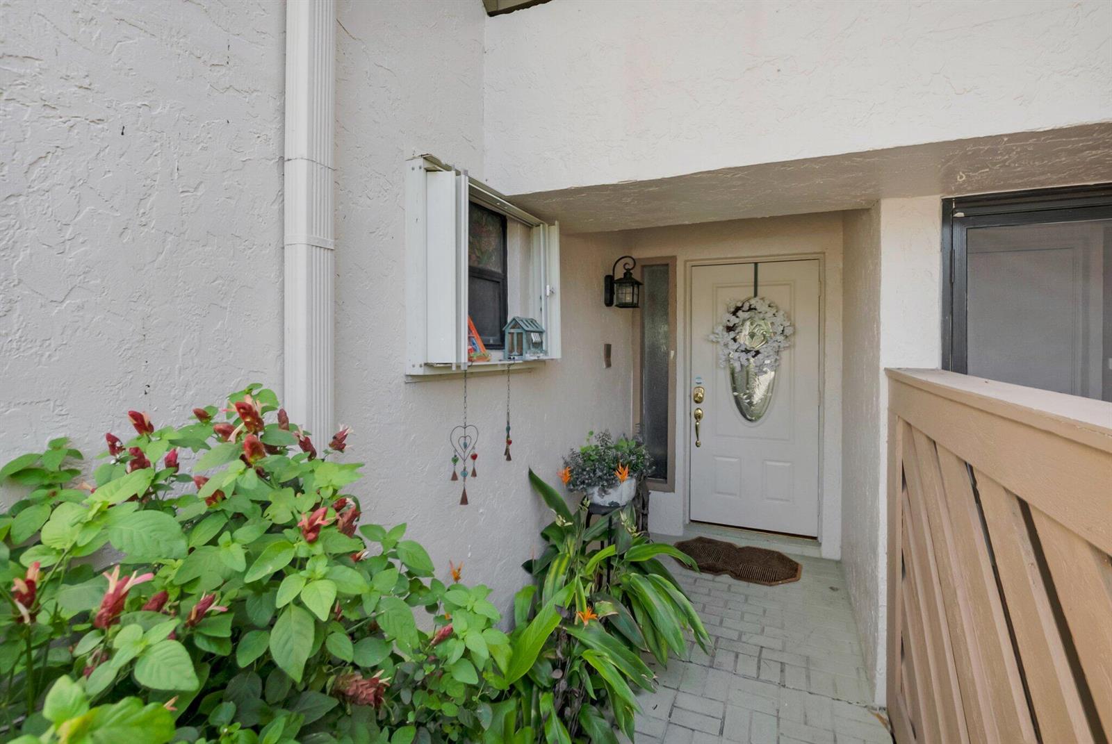 A paved entryway leads to a white front door with a decorative wreath and sidelight — 22922 Ironwedge Drive, Boca Raton FL 33433, BOCA RATON, FL