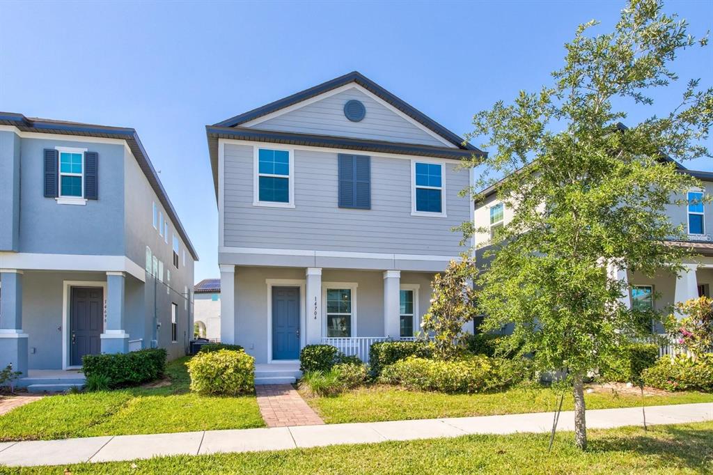A two-story light gray house with a blue front door and a small front porch — 14704 SETON CREEK BOULEVARD, WINTER GARDEN, FL
