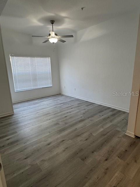 An empty room features light wood-look flooring, a ceiling fan, and a window with blinds — 2222 SAN VITTORINO CIRCLE UNIT 105, KISSIMMEE, FL