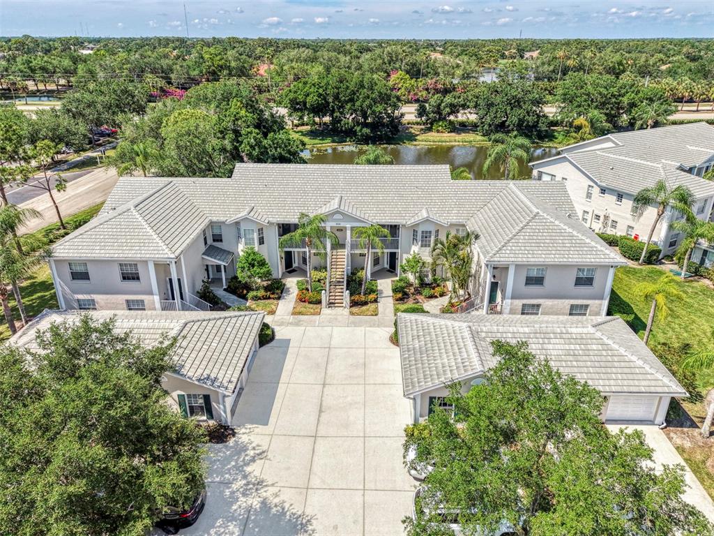 An aerial view shows a two-story apartment building with a central courtyard and parking area — 900 ADDINGTON COURT UNIT 203, VENICE, FL
