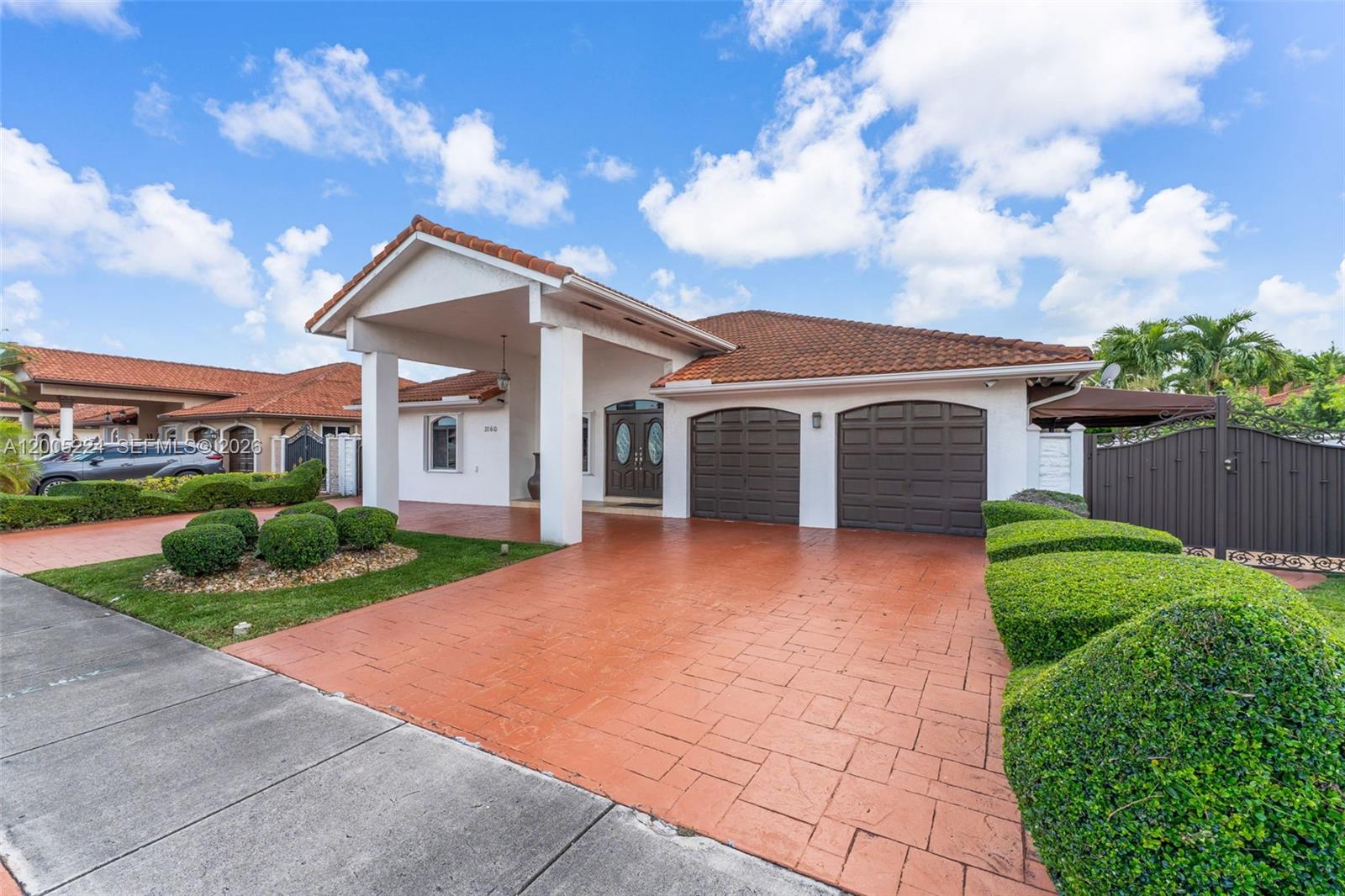 A single-story house features a covered entryway, a two-car garage, and a paved driveway — 3160 SW 142nd Ave, Miami FL 33175, MIAMI, FL