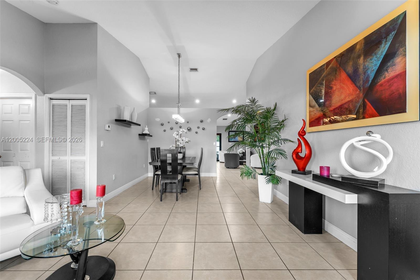 A dining area and entryway feature light tile floors, gray walls, and modern decor — 3160 SW 142nd Ave, Miami FL 33175, MIAMI, FL