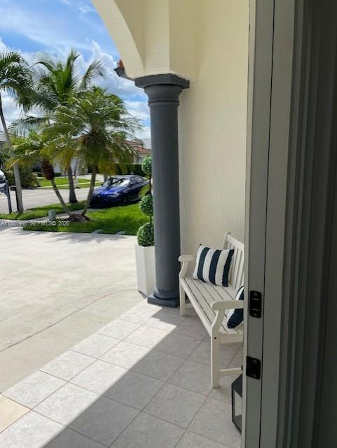 A white bench sits on a tiled porch next to a dark gray column — 18214 SW 144th Pl, Miami FL 33177, MIAMI, FL