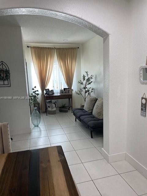 A tiled living area features an arched entryway, a dark sofa, and a wooden console table — 18214 SW 144th Pl, Miami FL 33177, MIAMI, FL