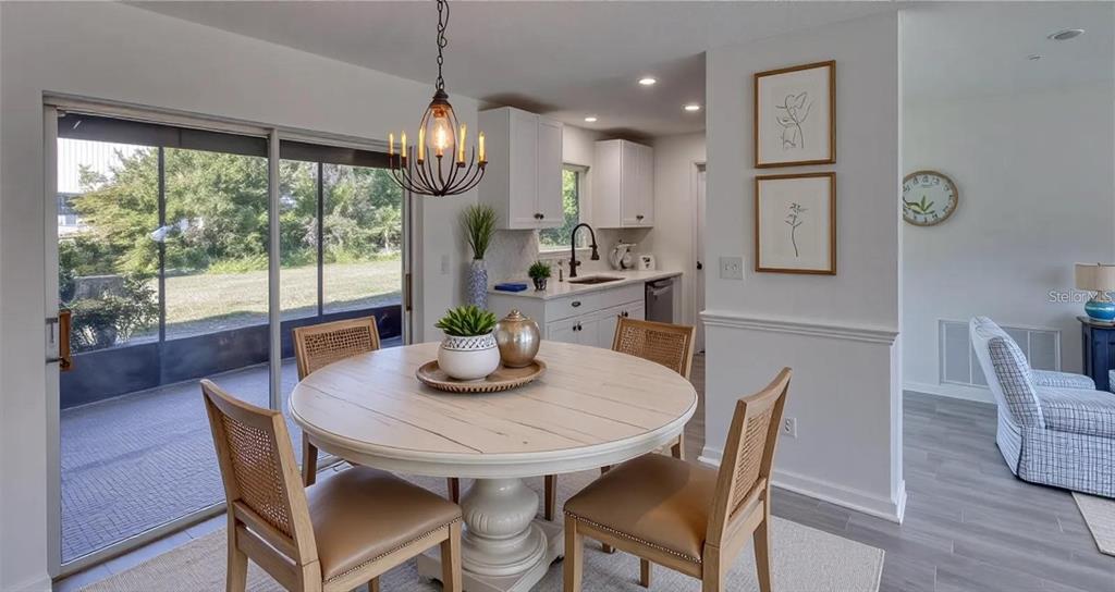 A dining area with a round table, four chairs, and a view of the backyard — 4318 GREAT LAKES DRIVE N, CLEARWATER, FL