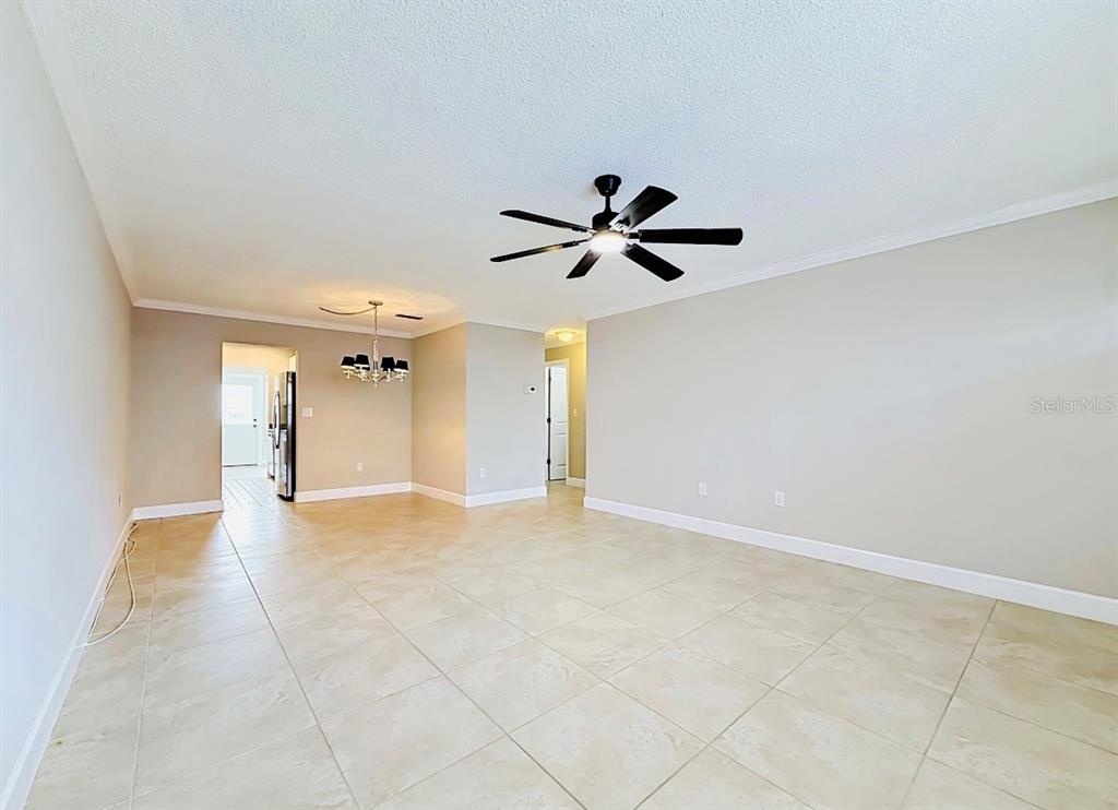 An open living area features light tile flooring, a ceiling fan, and a dining space — 6025 SHORE BOULEVARD S UNIT 106, GULFPORT, FL