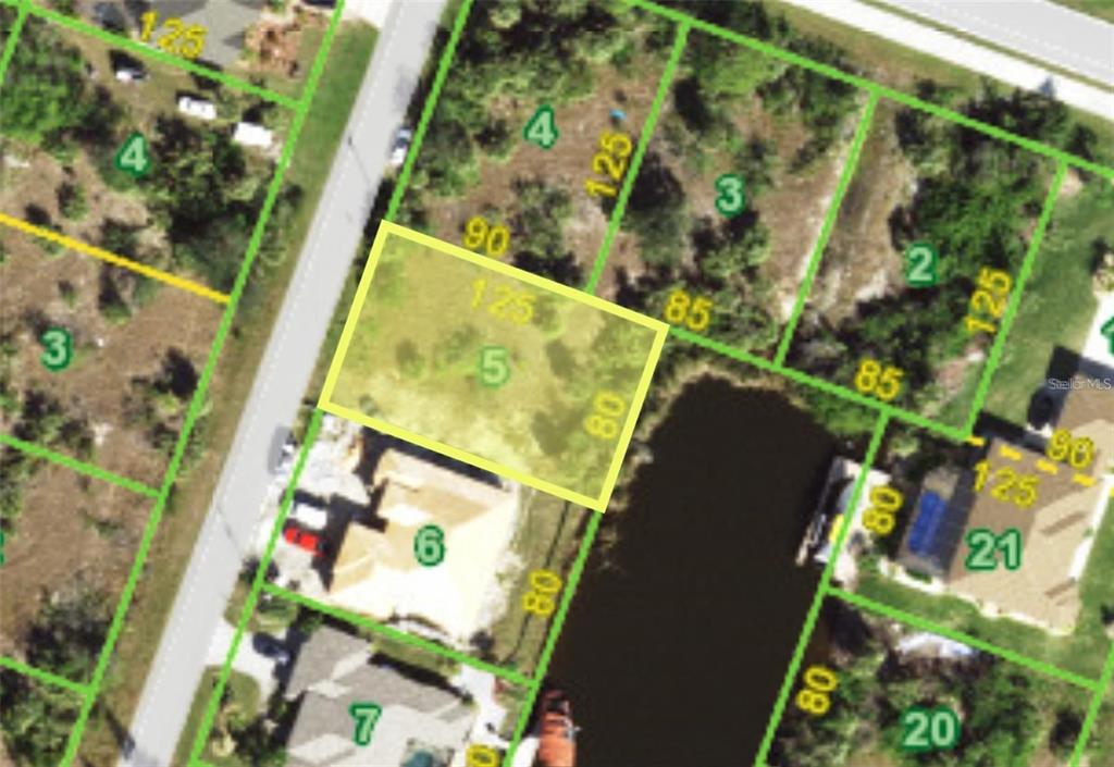 This is an aerial map showing a vacant residential lot highlighted in yellow — 9444 MIGUE CIRCLE, PORT CHARLOTTE, FL