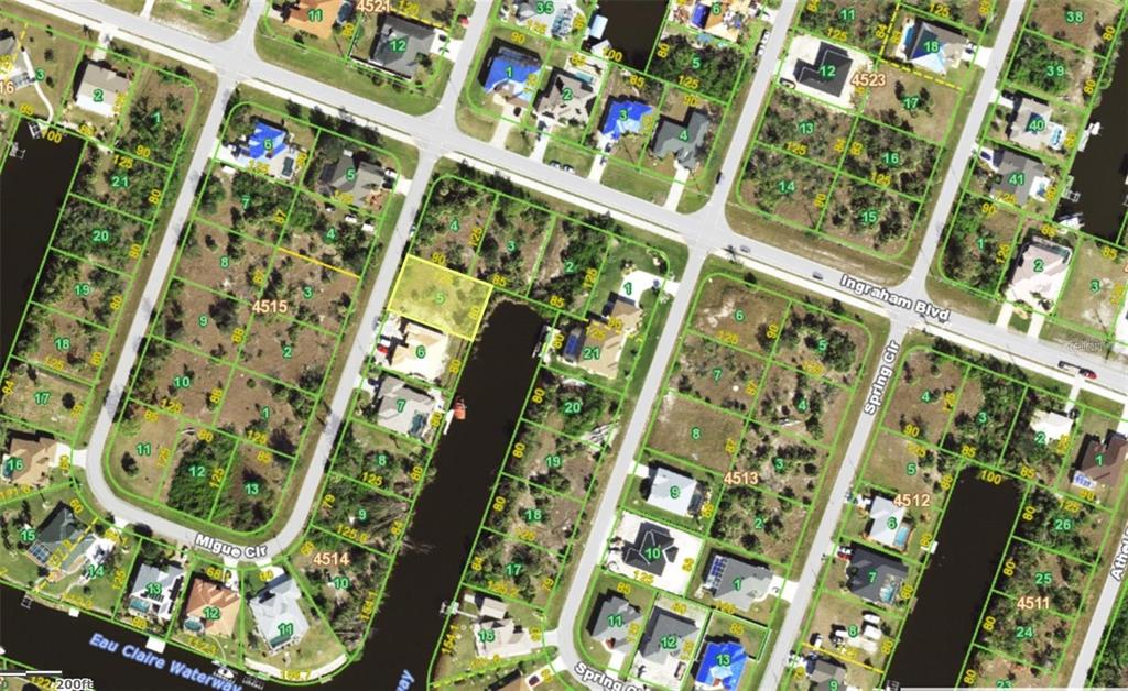 This is an aerial map showing residential lots and a waterway in a neighborhood — 9444 MIGUE CIRCLE, PORT CHARLOTTE, FL