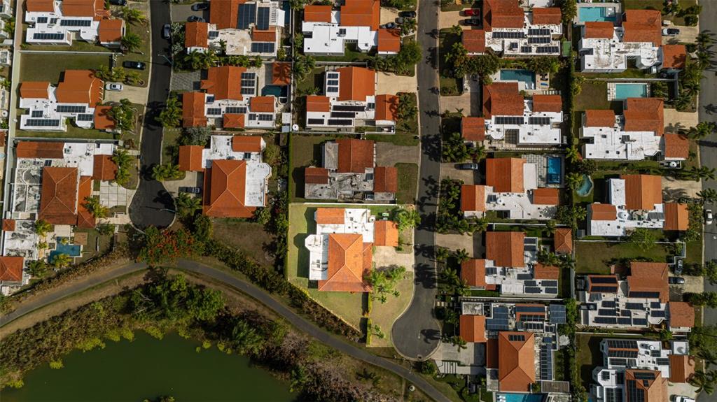 An aerial view shows a suburban neighborhood with houses featuring orange tile roofs and pools — 451 CAMINO GUAJATACA, DORADO, PR