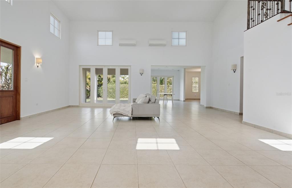 A spacious, high-ceilinged living room with white walls, tile flooring, and a central sofa — 451 CAMINO GUAJATACA, DORADO, PR
