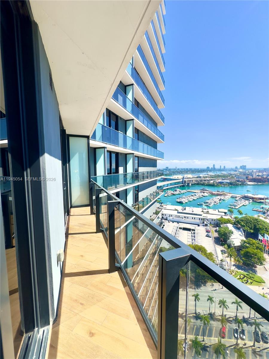 A high-rise balcony with glass railings overlooks a marina, city skyline, and coastal water — 398 NE 5th St # 2114, Miami FL 33132, MIAMI, FL