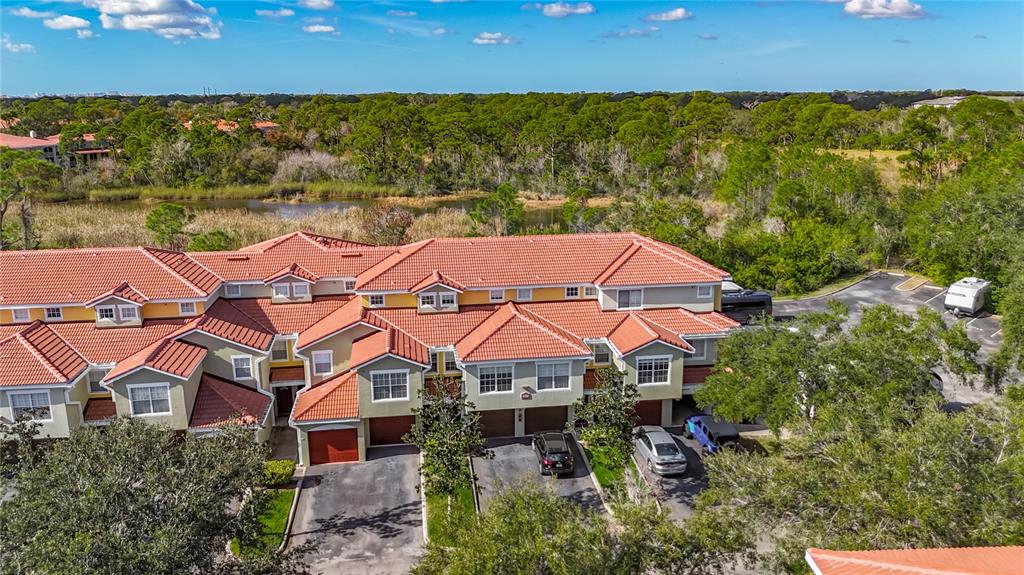 An aerial view of a multi-unit townhouse complex with orange tile roofs and driveways — 4990 BARALDI CIRCLE UNIT 209, SARASOTA, FL