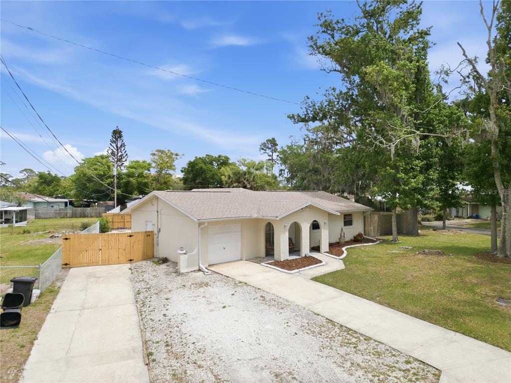 A single-story house with a white exterior, a garage, and a concrete driveway — 2861 W OAK LEA DRIVE, SOUTH DAYTONA, FL