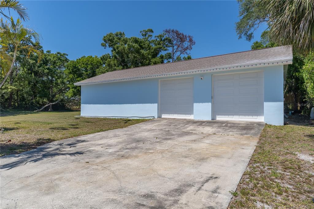 A light blue detached two-car garage sits at the end of a concrete driveway — 12705 PARK BOULEVARD, SEMINOLE, FL