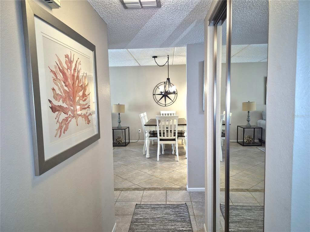 A view from a hallway looking into a dining area with tile flooring and furniture — 50 WOODLAKE PLACE, OLDSMAR, FL